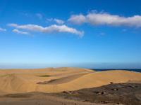Wolkenschiffchen am Himmel über den Maspalomas Dünen im Abendlicht